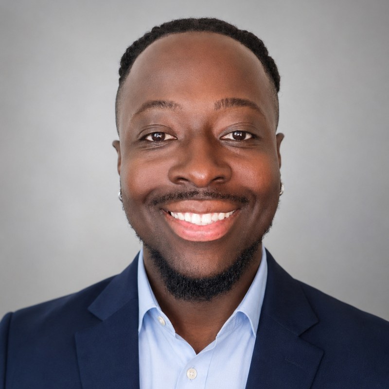 Augustine Mensah, MSN, BSPH, APRN, PMHNP-BC, smiling in a navy jacket and light blue shirt.